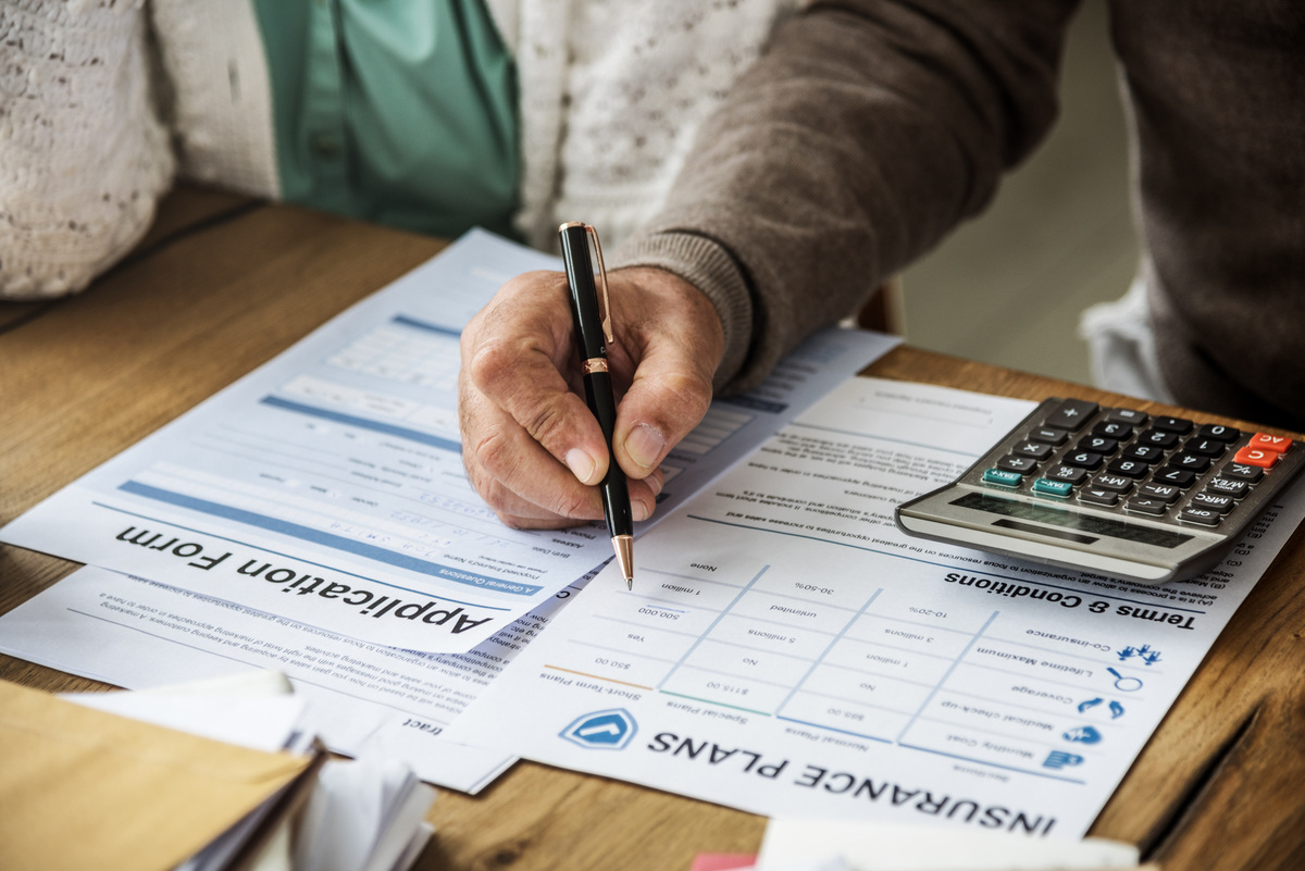 Does insurance cover Spravato? Person reviewing insurance plan documents with a pen and calculator